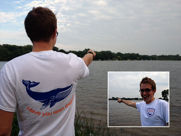 man in whale watching t-shirt points them out