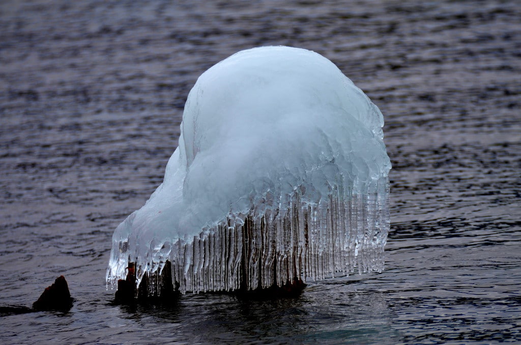 snow formation on rock with skirt of icicles in lake superior