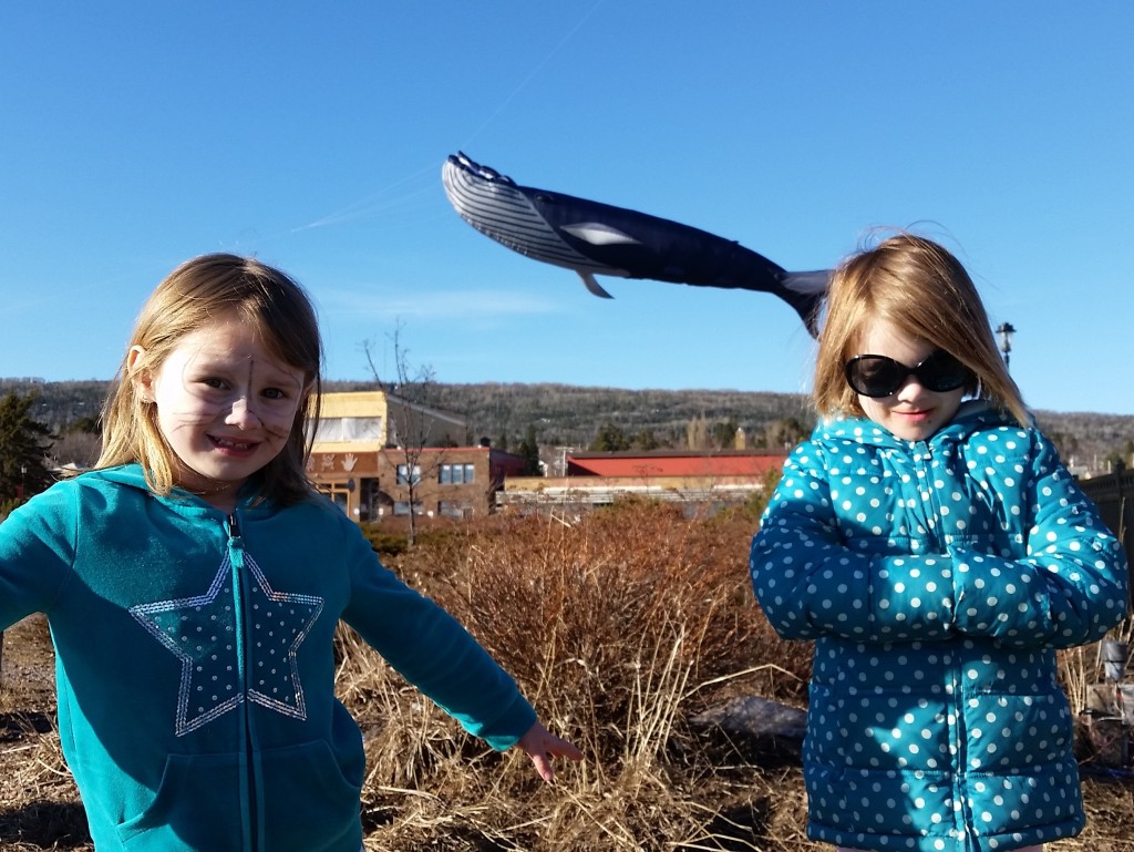 two girls in polka dot turquoise don't realize a whale is passing by